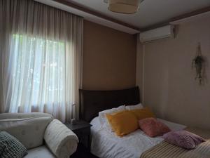 a bedroom with a bed with yellow pillows and a window at Ground floor Apt with a garden view in Limassol