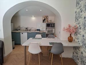 a kitchen with a table and chairs in a room at La Vie Est Belle in Salles-la-Source
