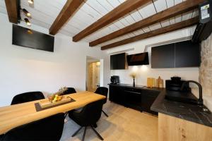 a kitchen with a wooden table and black cabinets at Filindvor in Nin