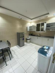 a large kitchen with a table and a refrigerator at الكادي للشقق المخدومة in Ad Dawādimī +14 photos