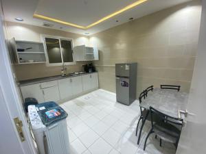 a small kitchen with a table and a refrigerator at الكادي للشقق المخدومة in Ad Dawādimī