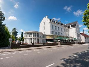 a large white building on the side of a street at Hotel 2000 Valkenburg in Valkenburg