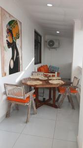 a living room with a table and a painting on the wall at Imani staycation Penthouse Diani in Diani Beach