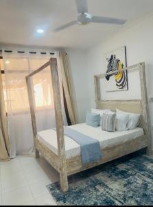a bedroom with a wooden bed in a room at Imani staycation Penthouse Diani in Diani Beach +33 photos