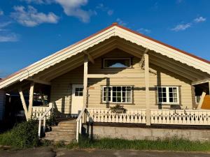 a white house with a porch and a balcony at Arctic Motel and Kautokeino Camping in Kautokeino