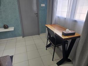 a desk in a room with a chair and a window at Domaine Béthania in Tadiénou +3 photos