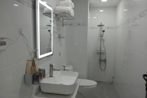 a white bathroom with a sink and a mirror at Ti Do Homestay in Ðức Hòa +35 photos