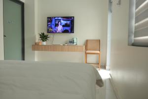 a bedroom with a bed and a tv on a wall at Ti Do Homestay in Ðức Hòa