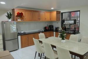 a kitchen with a table with chairs and a refrigerator at Ti Do Homestay in Ðức Hòa