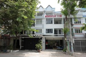 a white building with a sign on it at Ti Do Homestay in Ðức Hòa