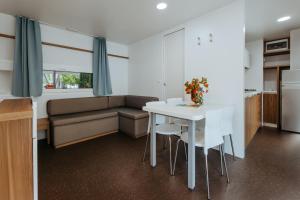 a living room with a white table and a couch at Green Garden Village con piscina, spiaggia riservata e parcheggio in Sirolo