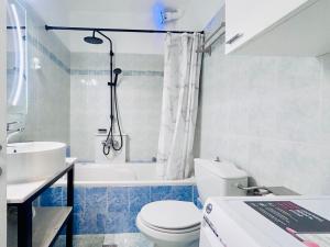a bathroom with a toilet and a tub and a sink at ITHACA Άνετο διαμέρισμα 3ου με θέα in Thessaloniki +17 photos
