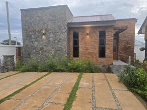 a brick house with a stone pathway in front of it at Verified Stone House in Dodoma