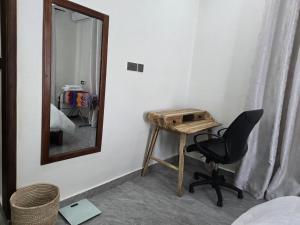 a mirror and a desk and a chair in a room at Verified Stone House in Dodoma +6 photos