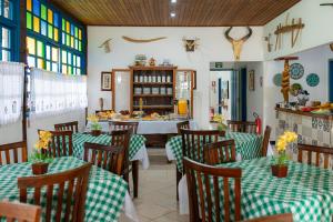 a restaurant with green and white tables and chairs at Pousada das Orquídeas in Pirenópolis