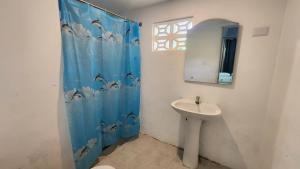 a bathroom with a sink and a shower curtain with dolphins at Boca de Yuma Adventure in Yuma +41 photos