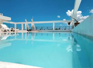 a swimming pool with the ocean in the background at Hotel Beach Pool Punta Cana Vacation in Punta Cana