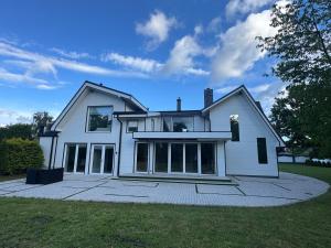 a large white house with a lot of windows at Kaleju 10 Apartment in Tukums