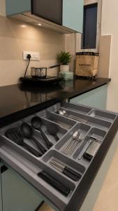 a stove top oven with utensils in a kitchen at Halfway Home Cozy 2bhk in Rājpur +5 photos