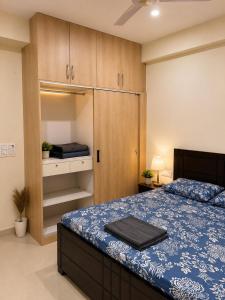 a bedroom with a bed and wooden cabinets at Halfway Home Cozy 2bhk in Rājpur