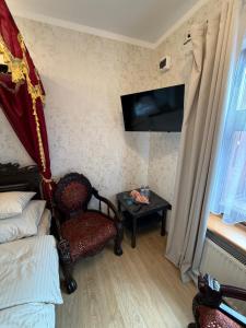 a room with a bed and a chair and a table at Tadż Mahal Apartament in Sulechów