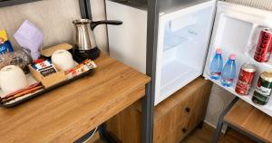 an open refrigerator with food and drinks on a wooden counter at Park and Fly Belgrade Airport Apartments in Surčin +18 photos