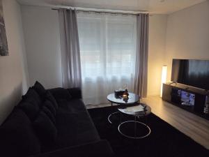 a living room with a couch and a table and a television at Ferienwohnung Lüchtringen in Höxter