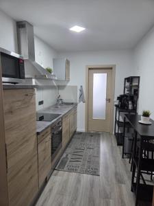 a kitchen with stainless steel appliances and a wooden floor at Ferienwohnung Lüchtringen in Höxter