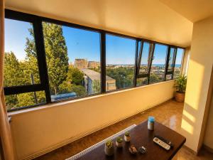 a living room with a table and a large window at Central plaja Neversea in Constanţa