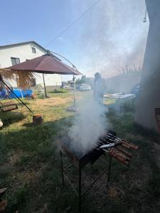 a man is cooking on a grill with smoke at Mega Life in Khashmi +10 photos