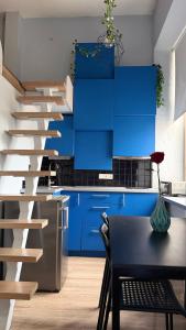 a kitchen with blue cabinets and a black table at Cozy Loft Studio, one open space, in great location in Vilnius