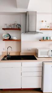 a kitchen with white cabinets and a sink at Hotel Beach Pool Punta Cana Vacation in Punta Cana