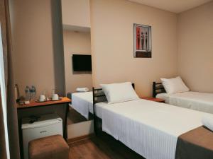 a hotel room with two beds and a table at Hotel Aura in Zugdidi +9 photos