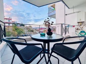 a table and chairs on a balcony with a view at ITHACA Άνετο διαμέρισμα 3ου με θέα in Thessaloniki