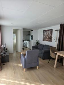 a living room with a couch and a table at Robin's oak lodge in Epe