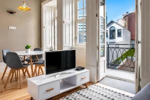 a living room with a flat screen tv on a white cabinet at MyStay Porto - Urban Collection in Porto