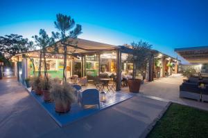 a house with a patio with tables and chairs at Country Resort Le Due Ruote in Alberese
