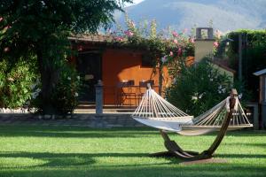 a hammock sitting in the grass in front of a house at Country Resort Le Due Ruote in Alberese