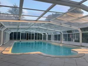 an indoor swimming pool with a glass roof at Château de Puchesse in Sandillon