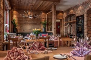 a dining room with wooden walls and tables with wine glasses at Arosa Vetter Hotel in Arosa