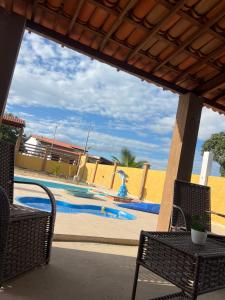 a swimming pool with two chairs and a fountain at Chácara Marias Da Serra in Araruna