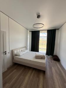a bedroom with a bed and a large window at Береке гостевой дом in Bosteri
