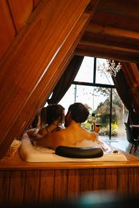 a man and a woman sitting in a bath tub at Cabana Amélia, em Gramado in Gramado