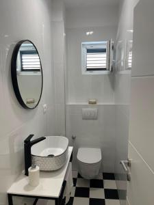 a white bathroom with a toilet and a mirror at Agata in Šibenik +18 photos