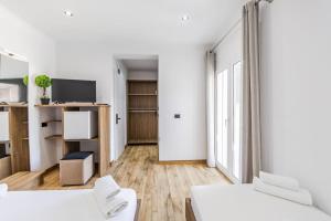 a living room with two white beds and a tv at Bliss by PikHost in Gjirokastër +153 photos