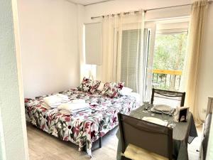 a bedroom with a bed and a table and a window at THE Estoril Studio in Estoril