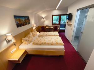 a hotel room with two beds and a table at Haus Dabaklamm in Kals am Großglockner