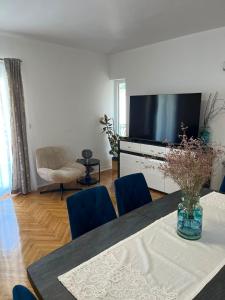 a living room with a table with chairs and a television at Agata in Šibenik
