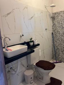 a bathroom with a sink and a toilet at Chácara Marias Da Serra in Araruna +19 photos