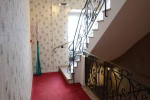 a hallway with a red carpet and stairs with a window at Logis Hôtel du Centre - Halte idéale en cyclotourisme avec garage à vélos clos in Molsheim